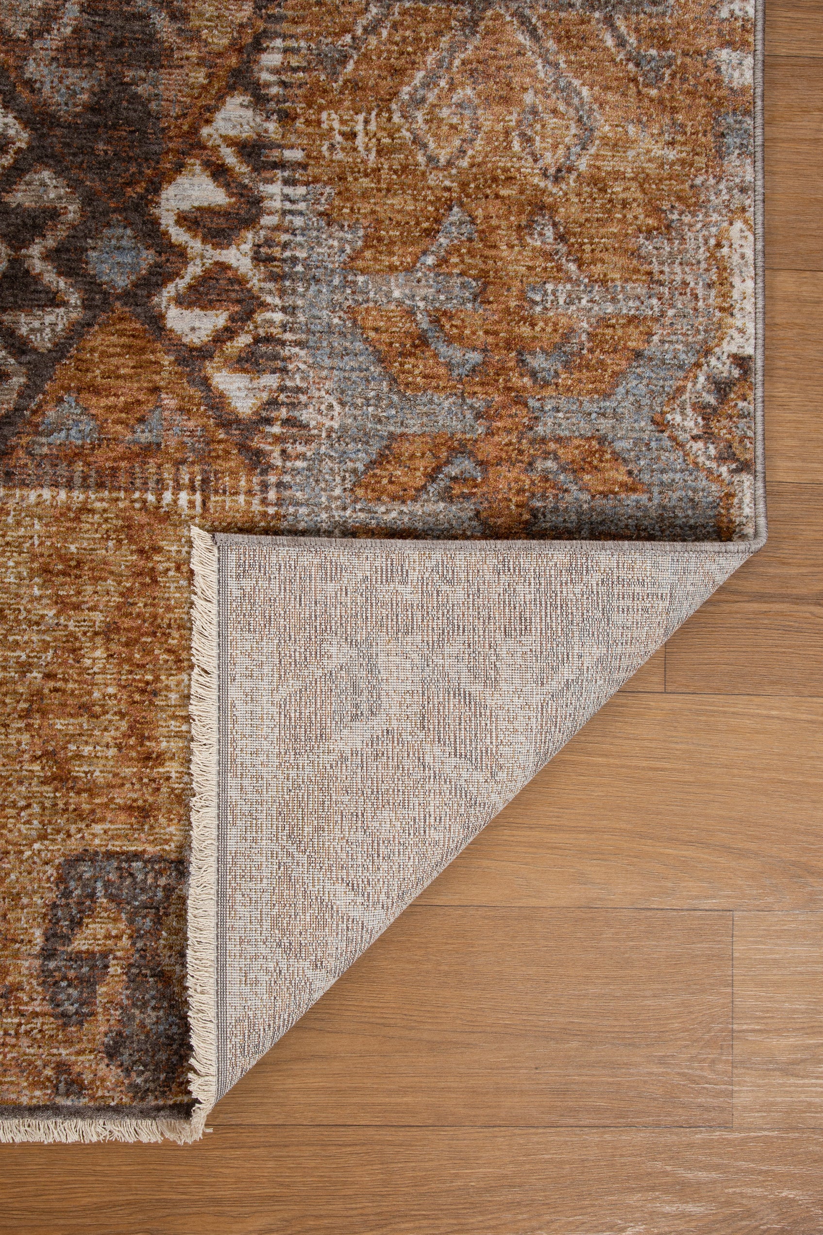 Blue book on tan wool rug with geometric cross pattern and tribal design
