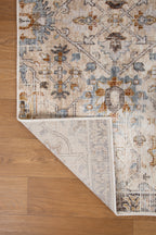 Vintage-style rug with intricate geometric patterns in cream, gold and blue tones