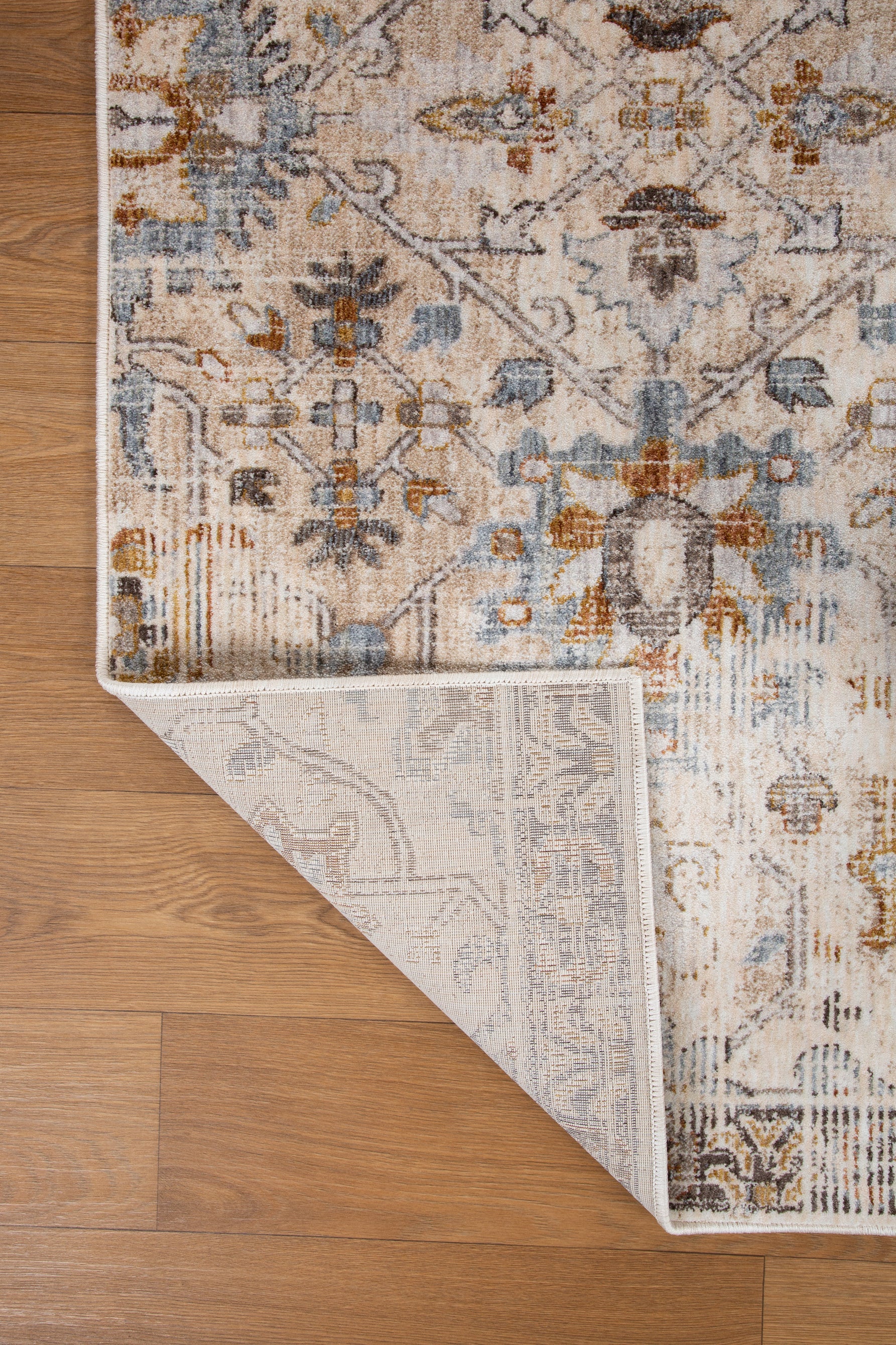 Vintage-style rug with intricate geometric patterns in cream, gold and blue tones