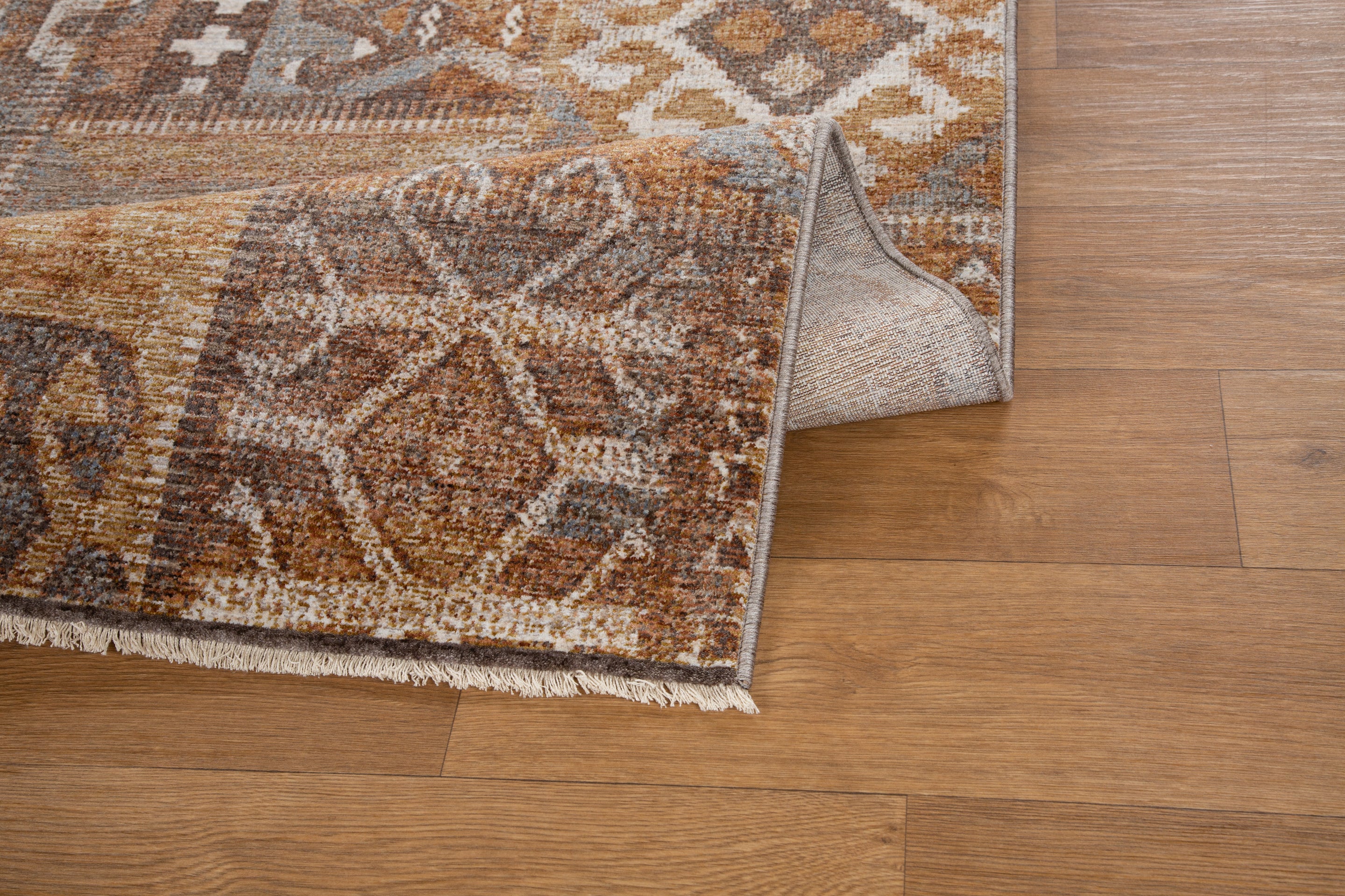 Blue book on tan wool rug with geometric cross pattern and tribal design