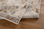 Vintage-style rug with intricate geometric patterns in cream, gold and blue tones