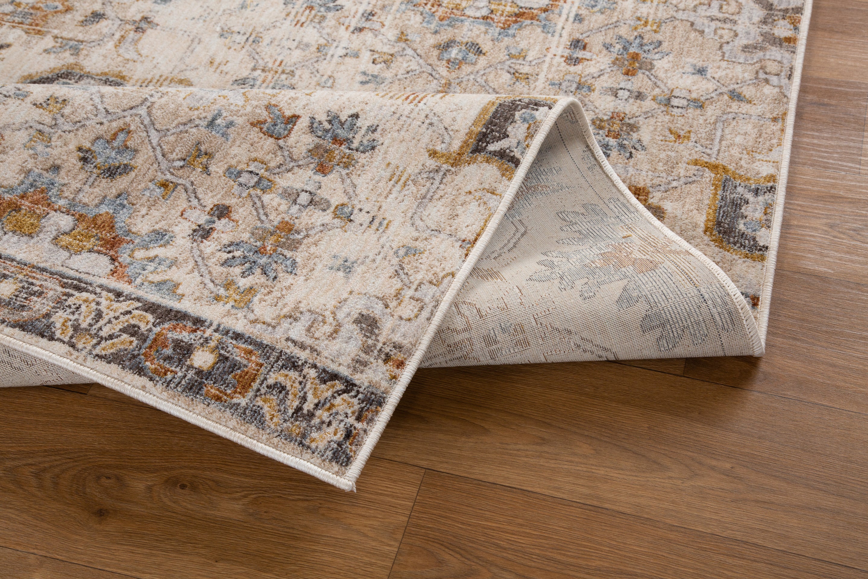 Vintage-style rug with intricate geometric patterns in cream, gold and blue tones