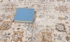 Vintage-style rug with intricate geometric patterns in cream, gold and blue tones