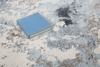 Modern distressed area rug with blue, grey and cream abstract paint splatter pattern