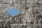 Abstract textured area rug in gray, cream, and charcoal with distressed vintage pattern