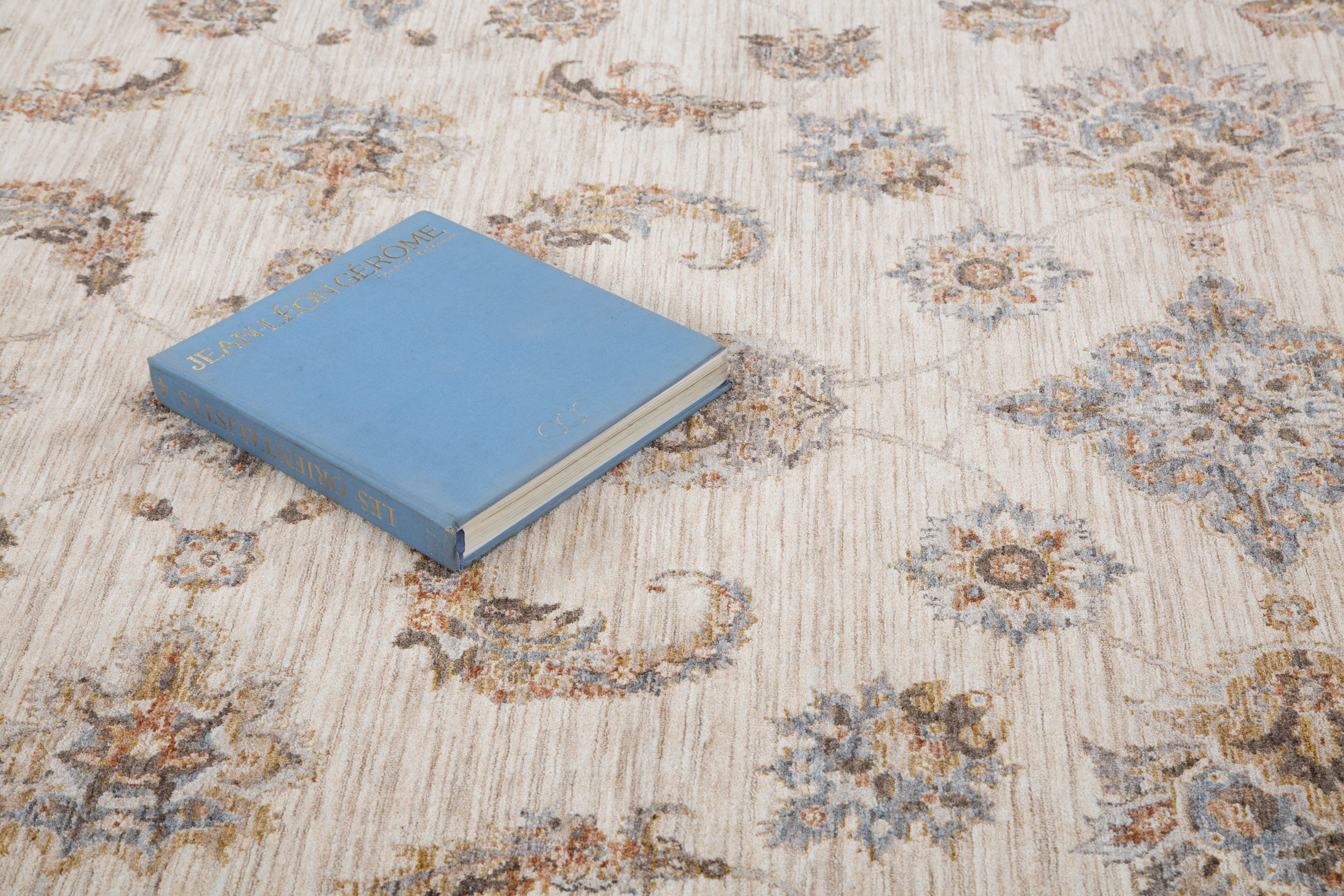 Cream traditional rug with ornate brown floral medallions and scrollwork border