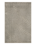 Beige quilted area rug with geometric pattern on wooden floor, corner detail