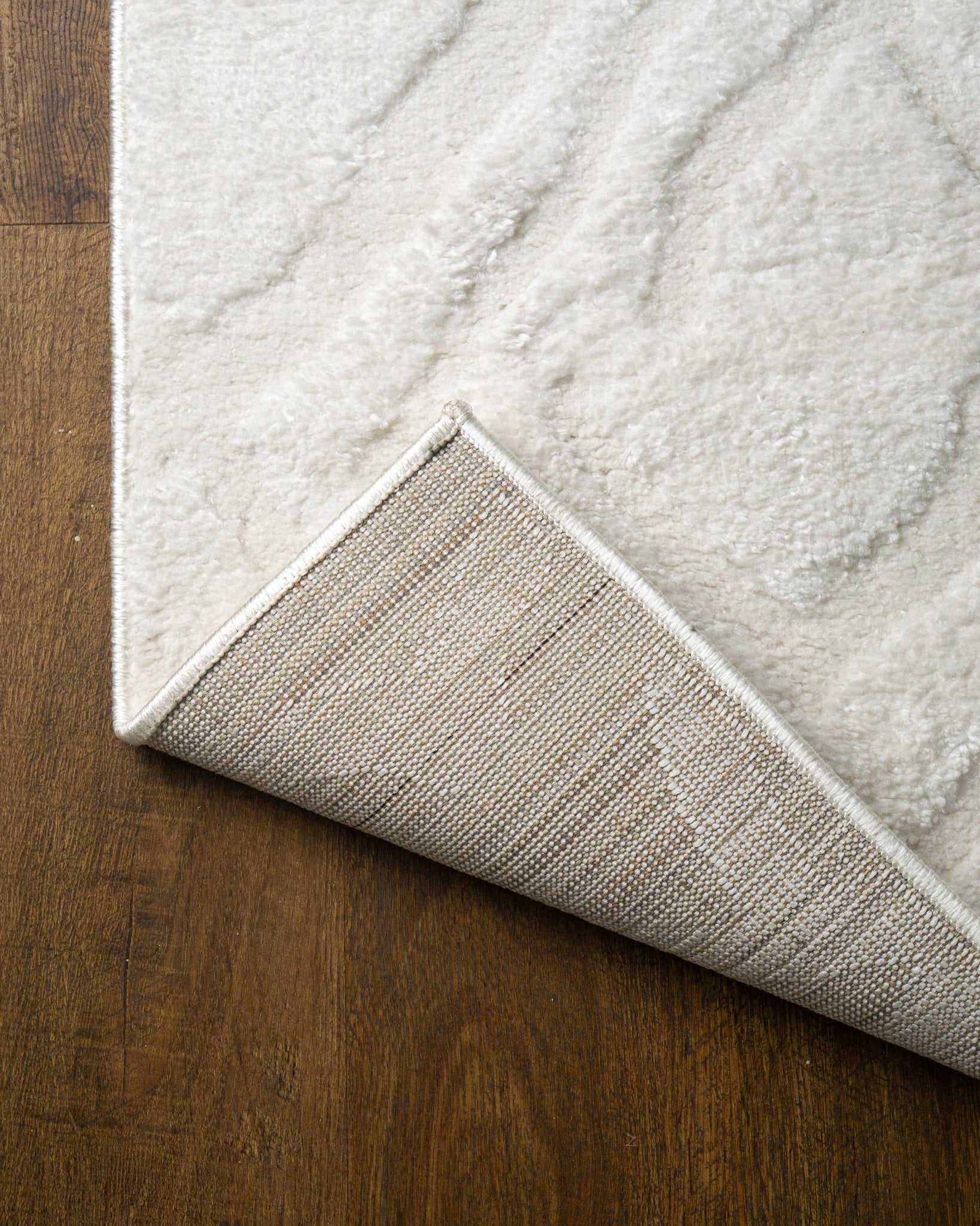 Cream textured rug with subtle geometric diamond pattern throughout