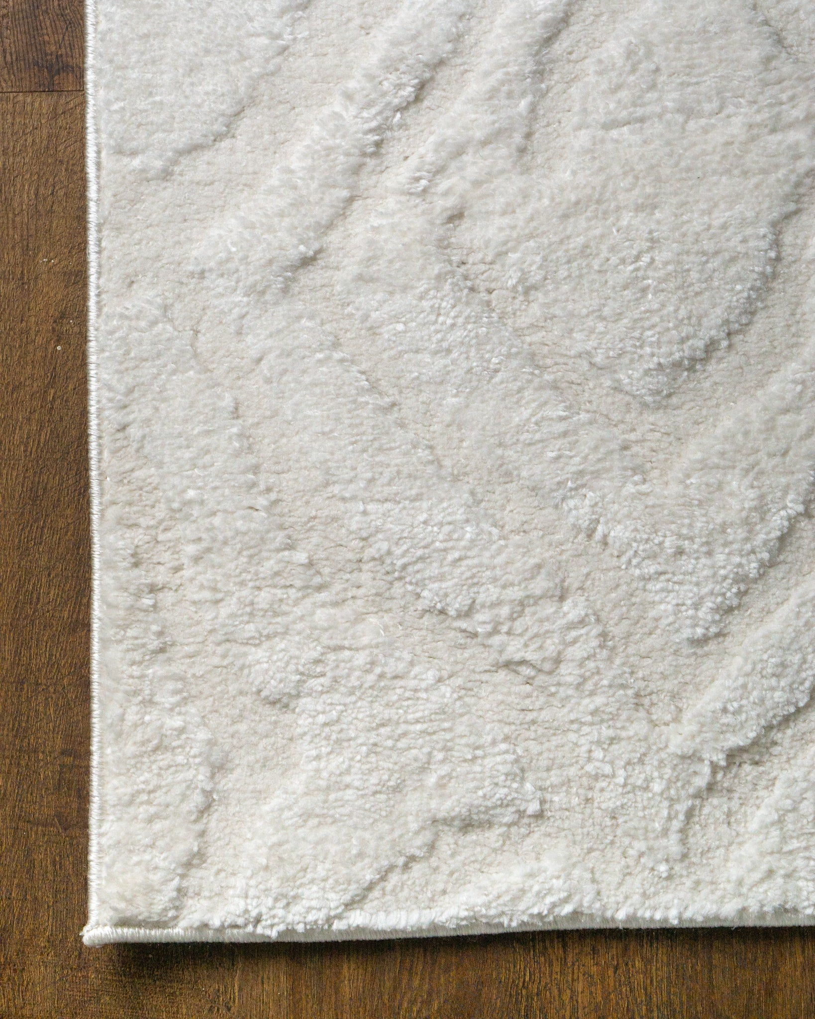 Cream textured rug with subtle geometric diamond pattern throughout