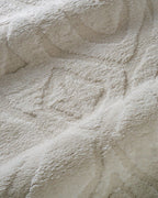 Cream textured rug with subtle geometric diamond pattern throughout