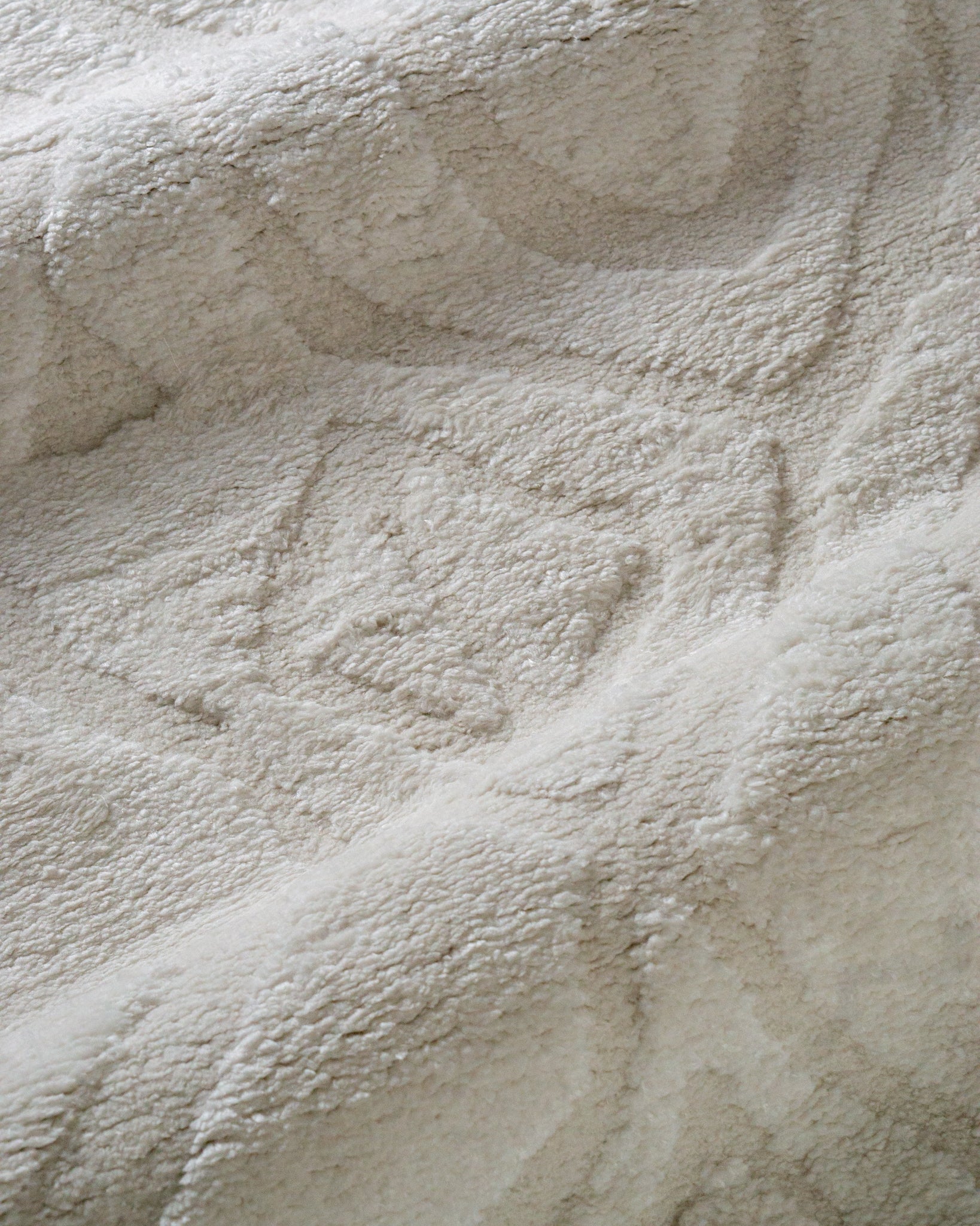 Cream textured rug with subtle geometric diamond pattern throughout
