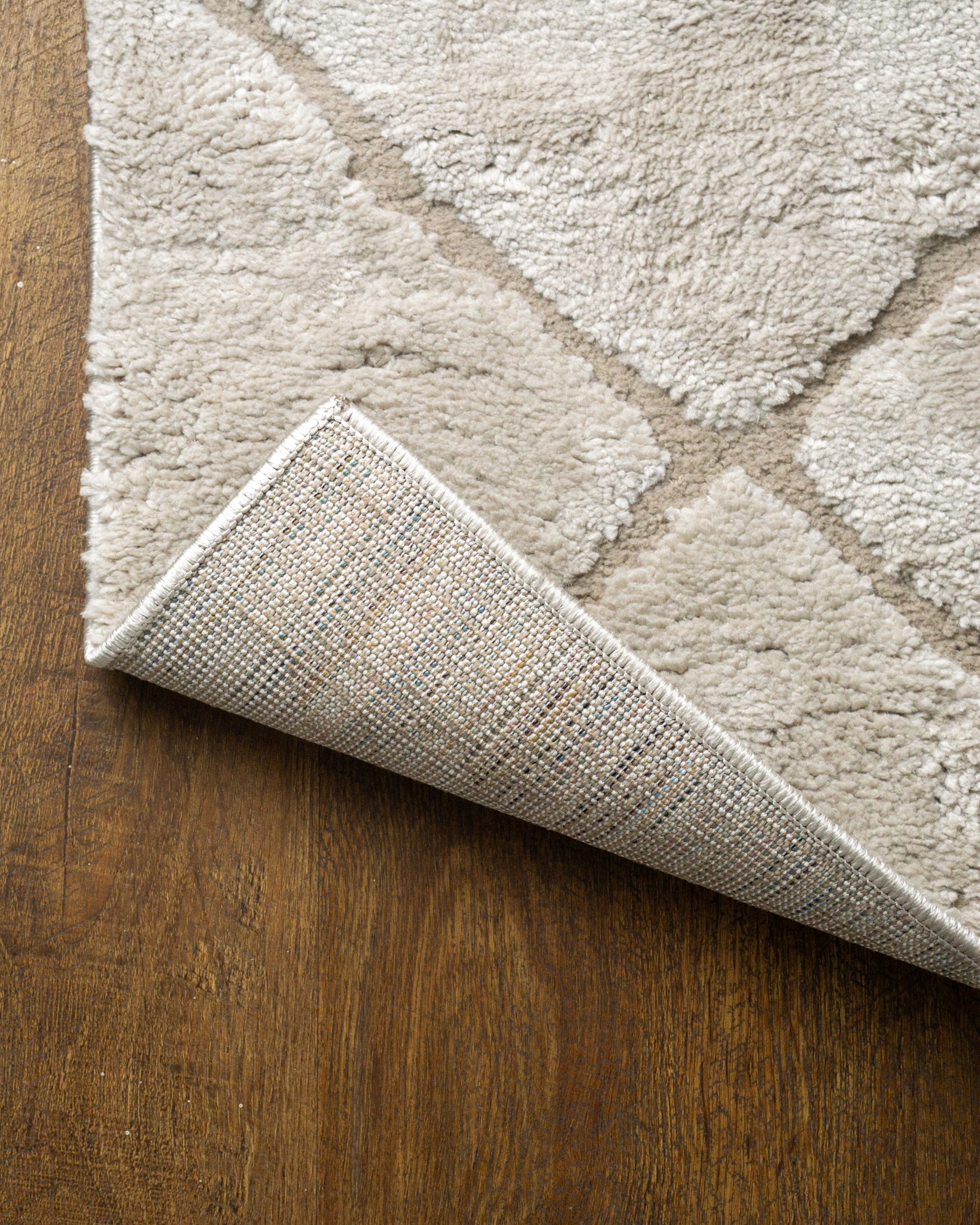 Beige geometric rug with diamond quilted pattern and subtle texture