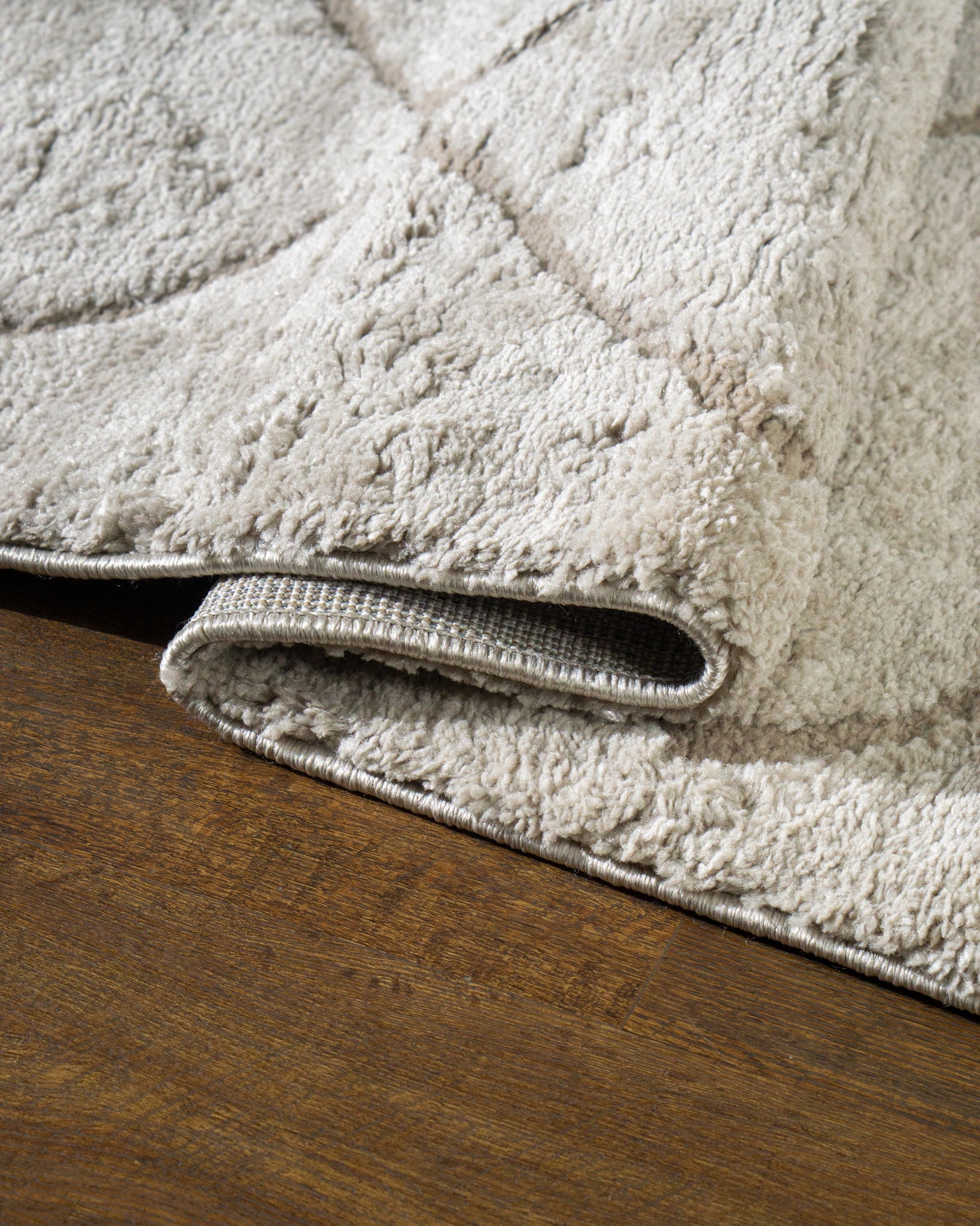 Beige geometric rug with diamond quilted pattern and subtle texture