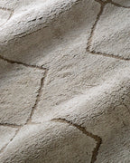 Beige geometric rug with diamond quilted pattern and subtle texture