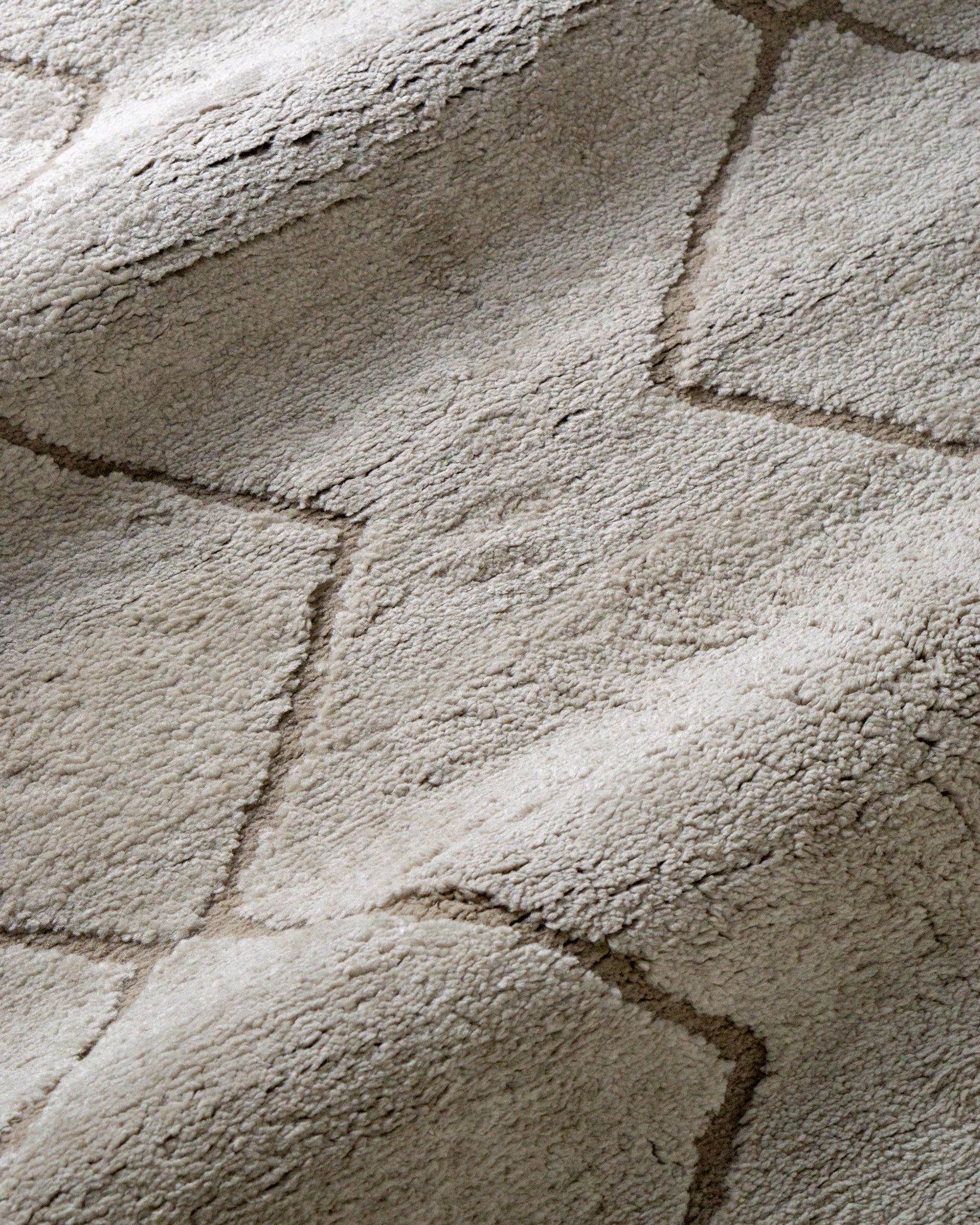 Beige geometric rug with diamond quilted pattern and subtle texture