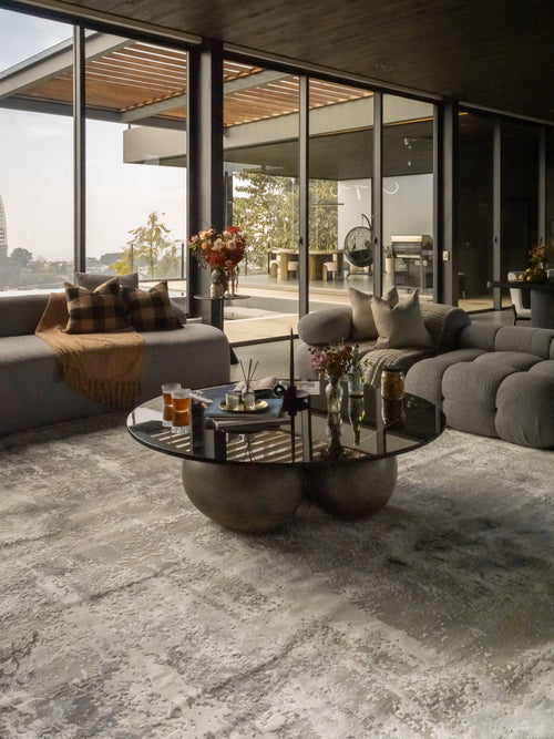 Distressed grey and white abstract area rug with weathered texture pattern