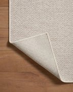Neutral beige herringbone textured rug with subtle woven pattern throughout