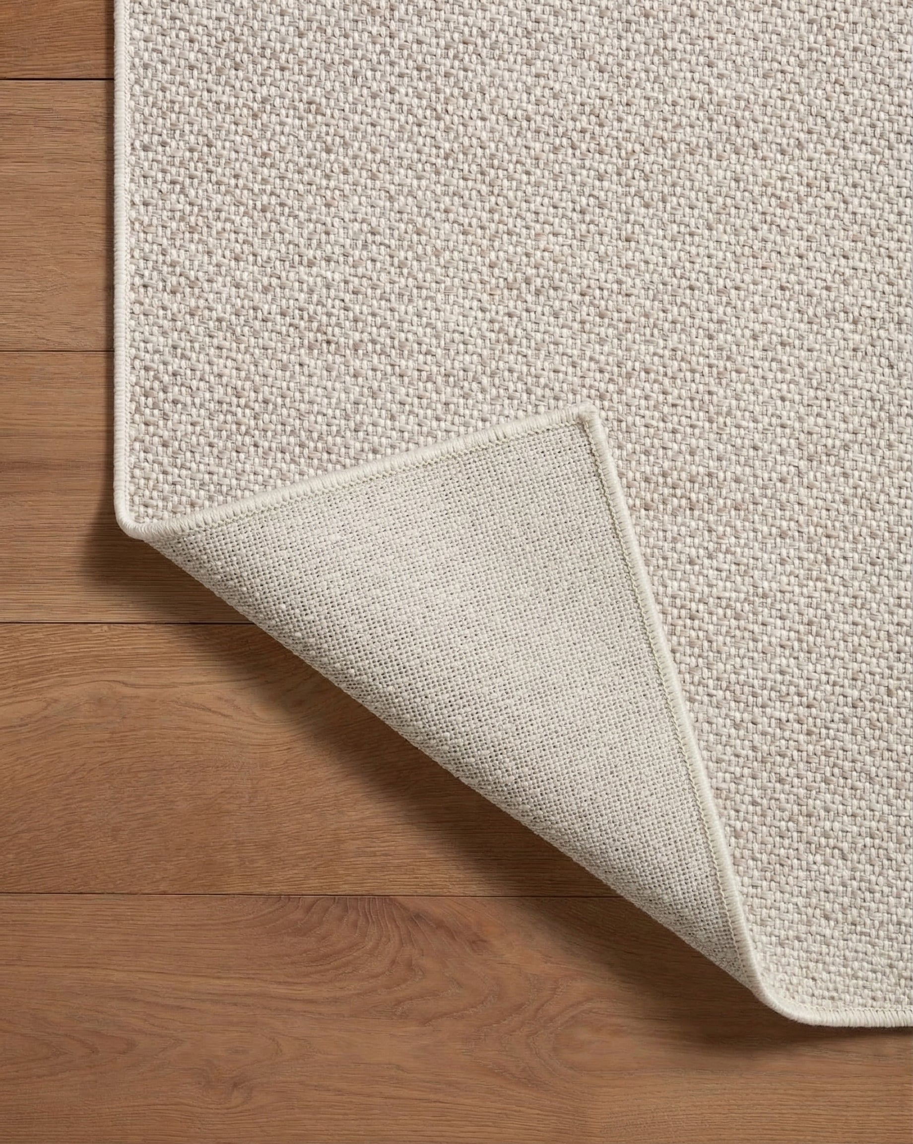 Neutral beige herringbone textured rug with subtle woven pattern throughout