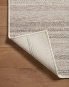 Neutral striped outdoor rug in beige and grey tones on patio