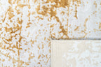 Gold and cream distressed texture rug with abstract weathered pattern