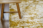 Distressed gold and cream area rug with vintage worn texture pattern