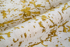 Distressed gold and cream area rug with vintage worn texture pattern