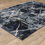 Modern distressed rug with dark navy and grey base, white splatter abstract pattern