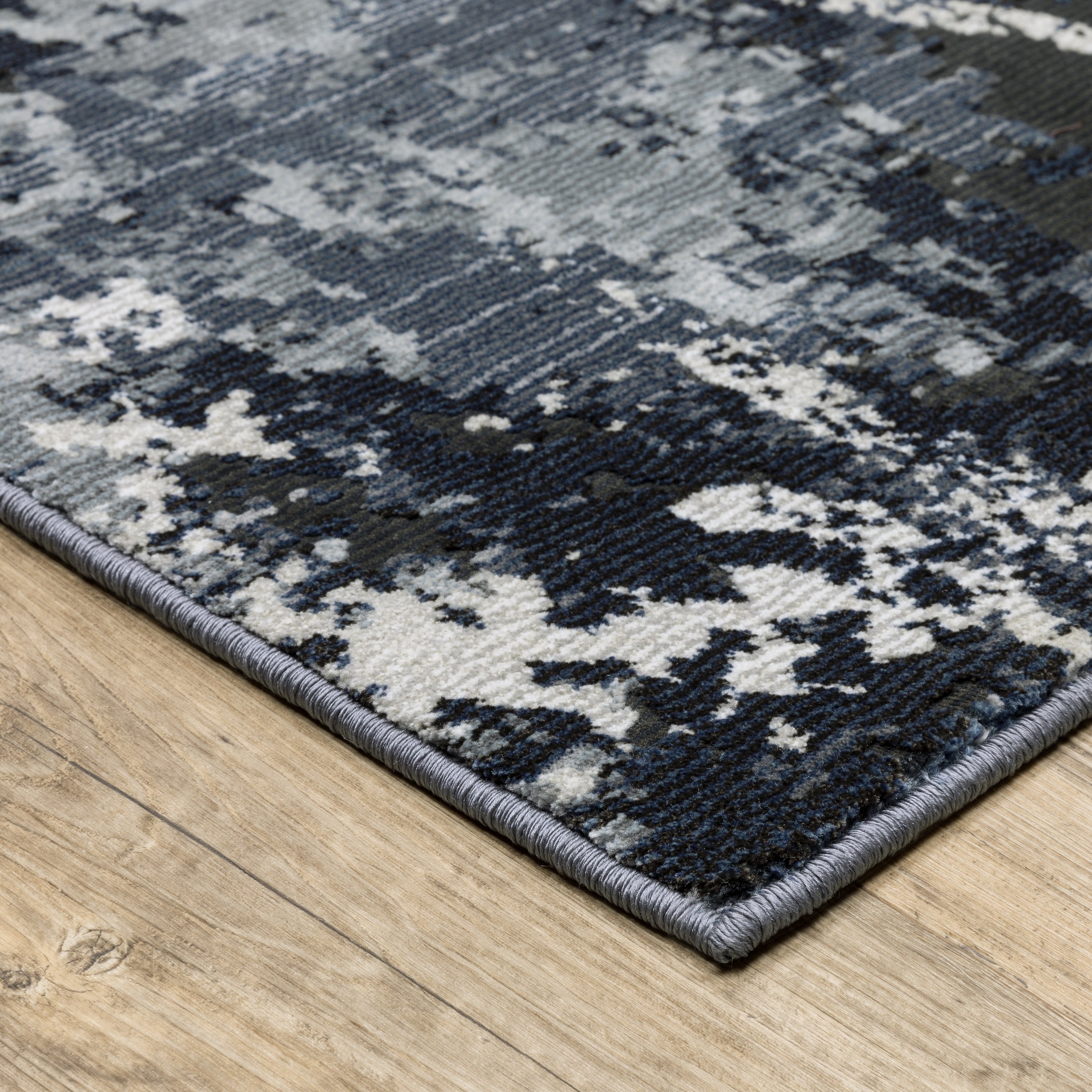 Modern distressed rug with dark navy and grey base, white splatter abstract pattern