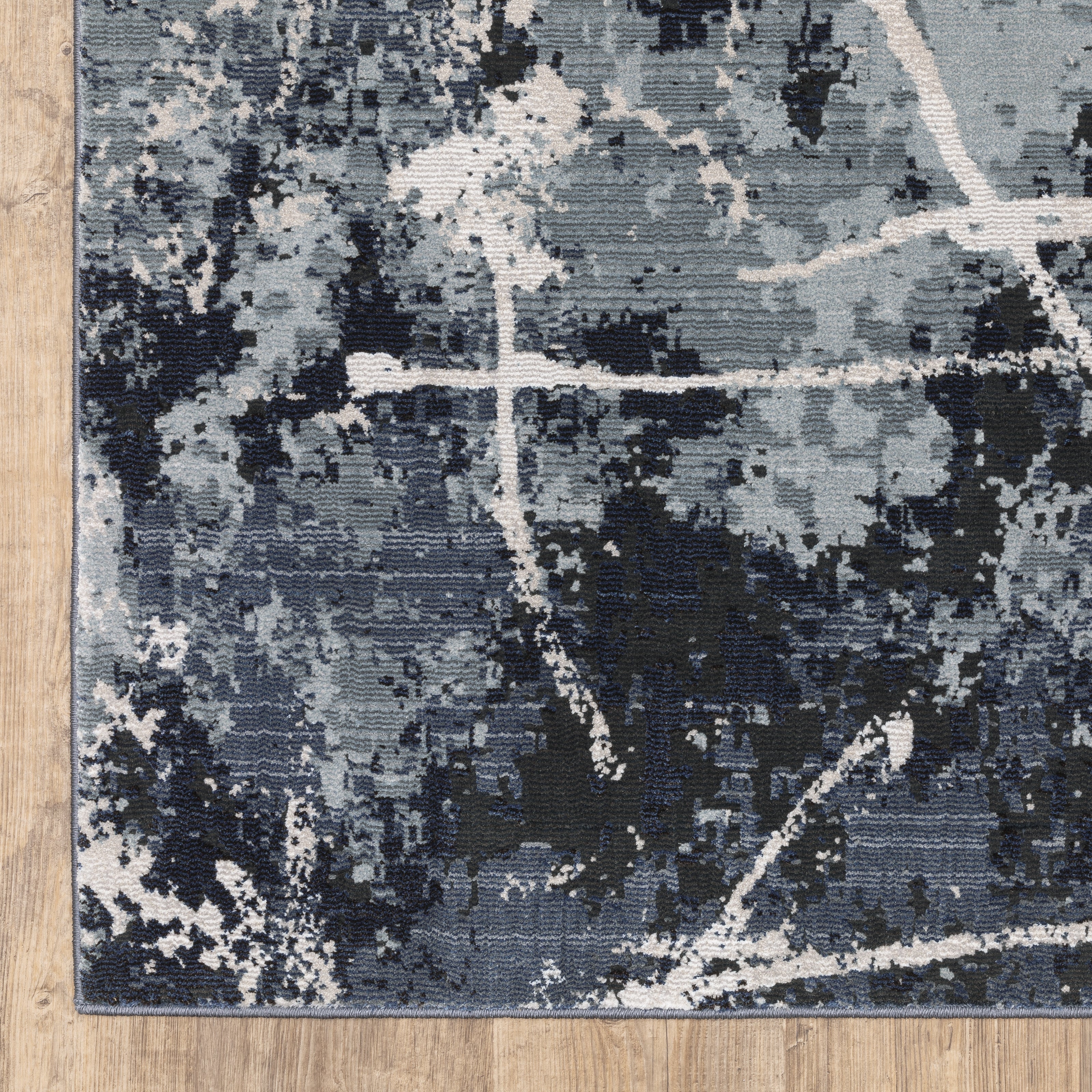 Modern distressed rug with dark navy and grey base, white splatter abstract pattern