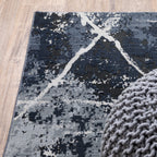 Modern distressed rug with dark navy and grey base, white splatter abstract pattern