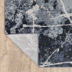 Modern distressed rug with dark navy and grey base, white splatter abstract pattern