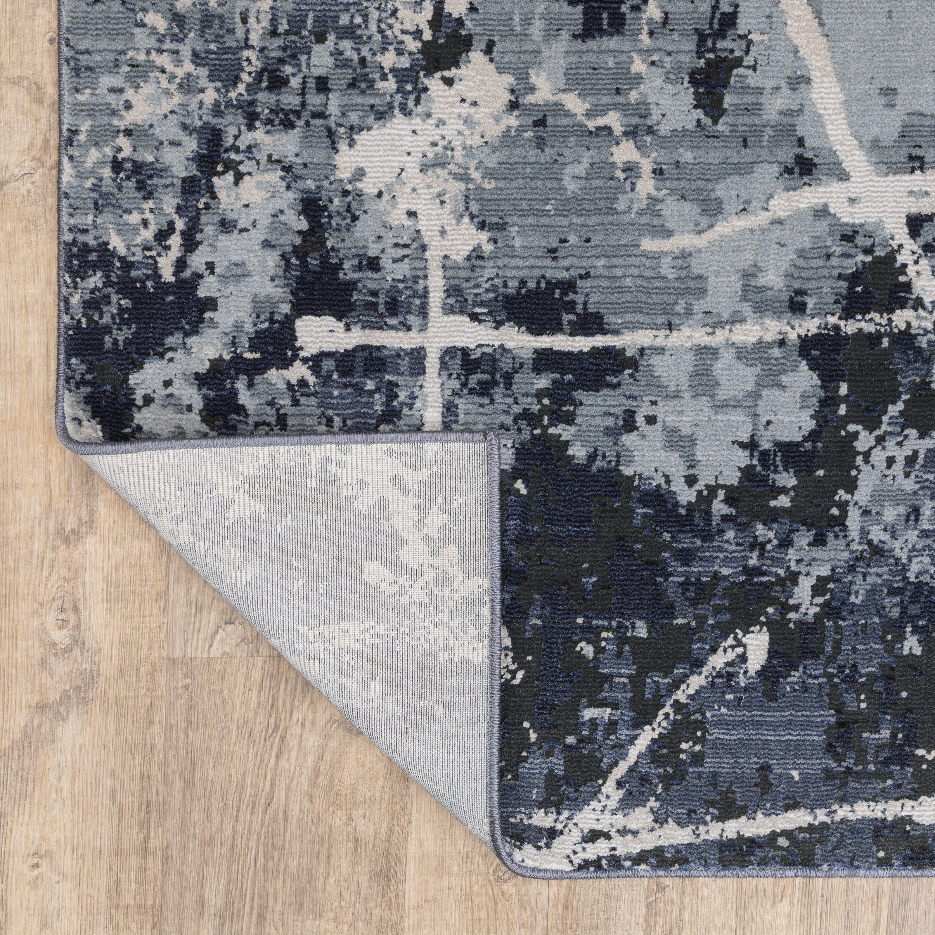 Modern distressed rug with dark navy and grey base, white splatter abstract pattern