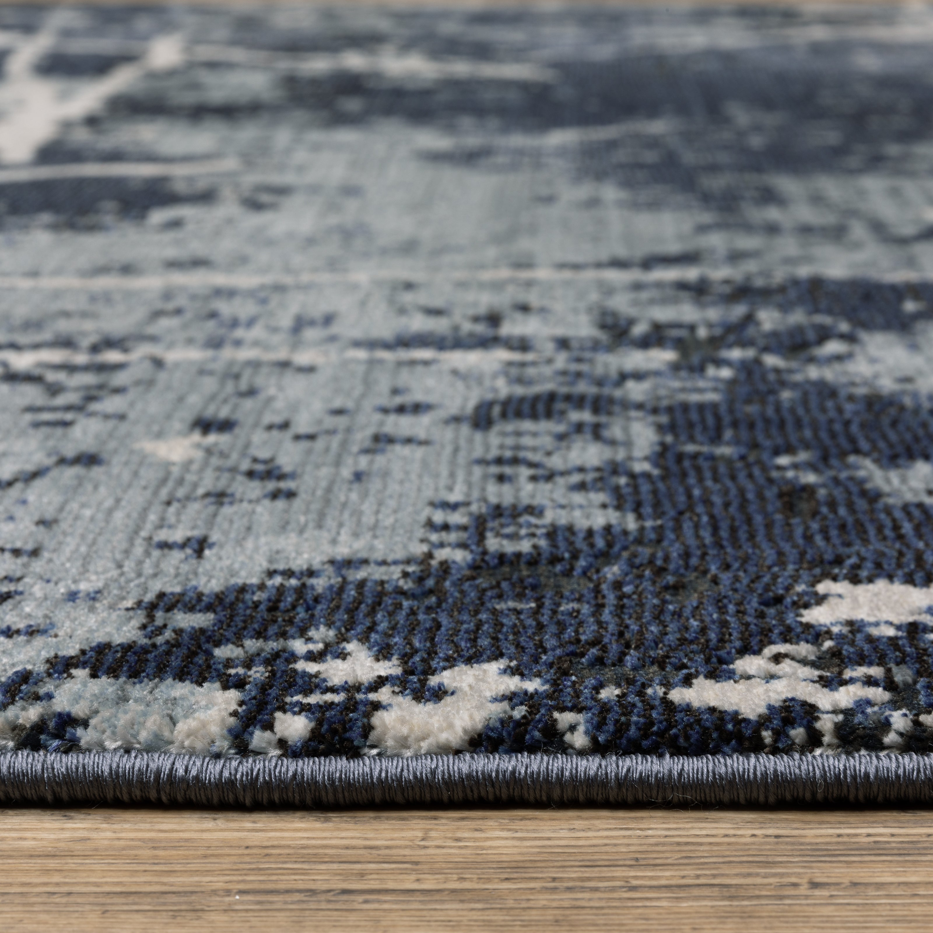 Modern distressed rug with dark navy and grey base, white splatter abstract pattern