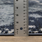 Modern distressed rug with dark navy and grey base, white splatter abstract pattern
