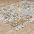 Modern abstract rug with distressed grey, gold, and blue tones featuring architectural patterns