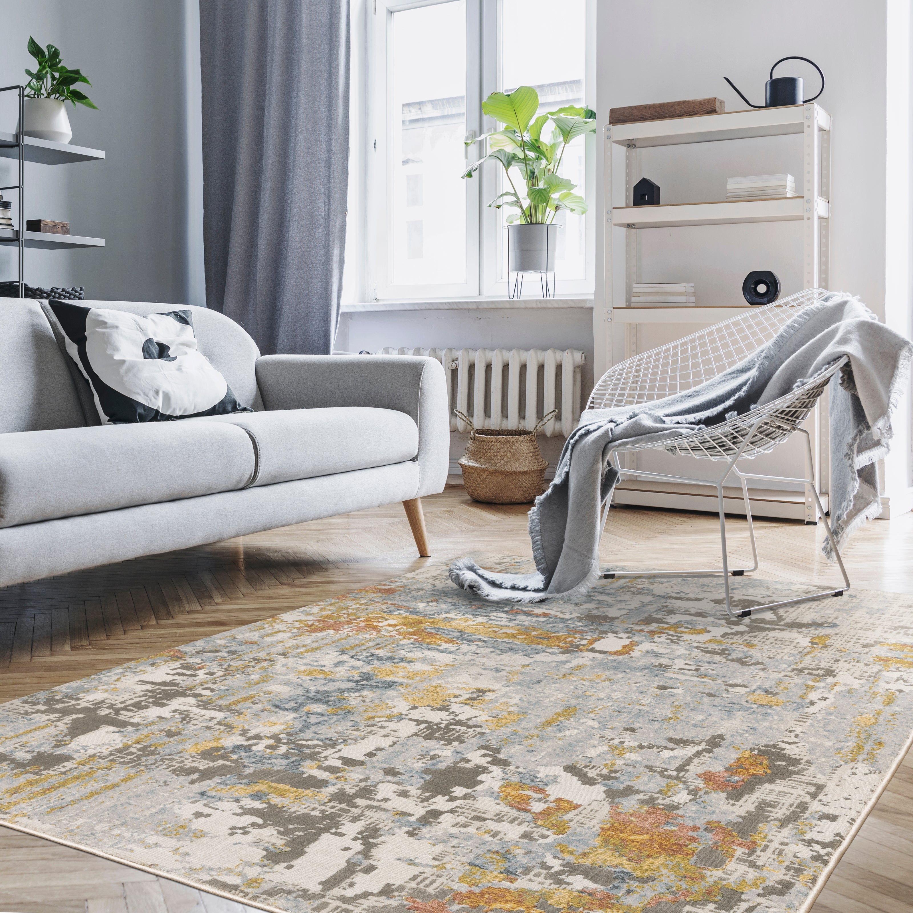 Modern abstract rug with distressed grey, gold, and blue tones featuring architectural patterns