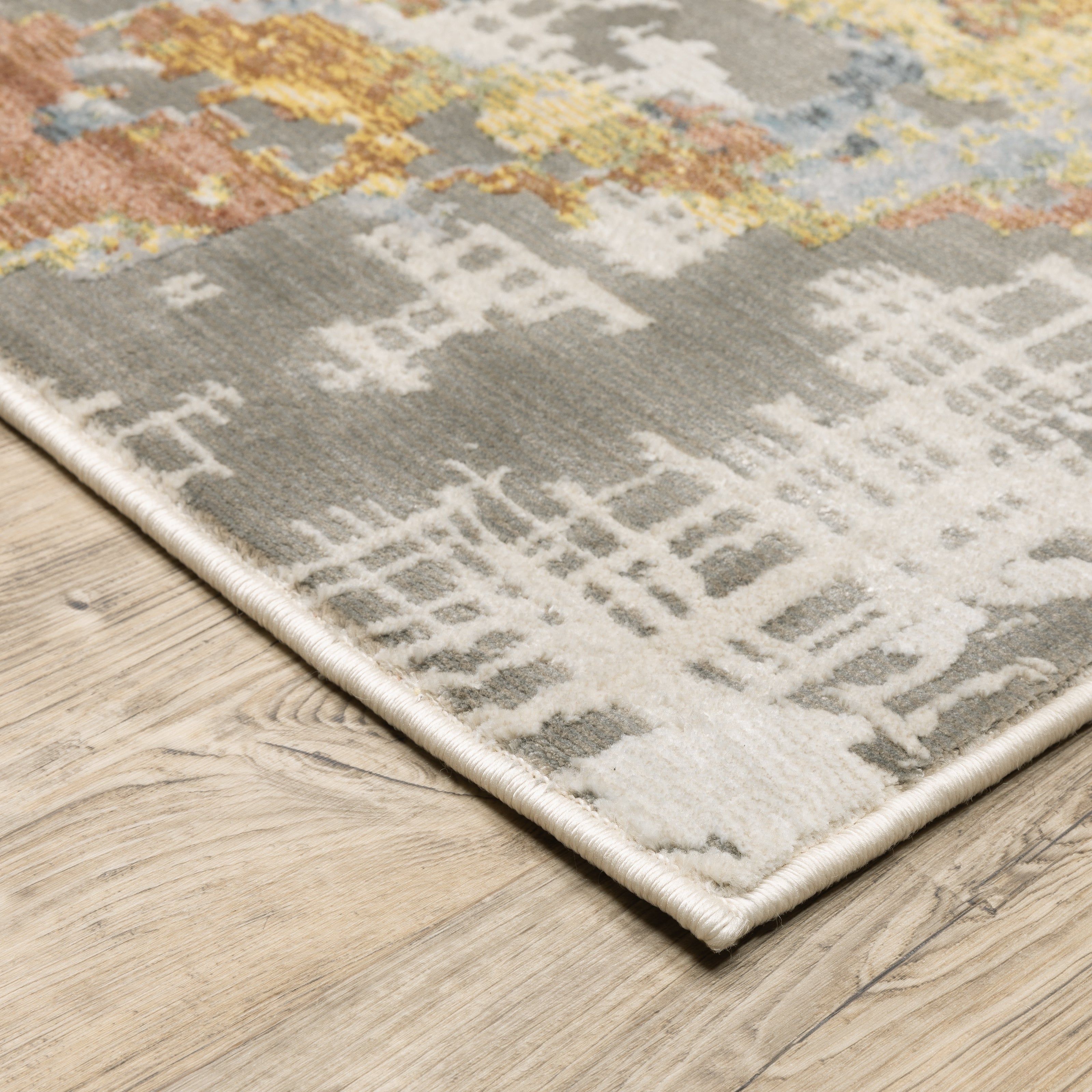 Modern abstract rug with distressed grey, gold, and blue tones featuring architectural patterns