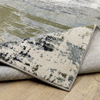 Abstract distressed area rug with grey, olive, and cream mottled texture pattern