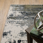 Abstract distressed area rug with grey, olive, and cream mottled texture pattern