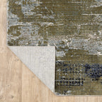 Abstract distressed area rug with grey, olive, and cream mottled texture pattern