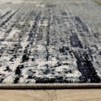 Abstract distressed area rug with grey, olive, and cream mottled texture pattern