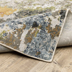 Modern abstract area rug with distressed gold, gray, and blue speckled pattern