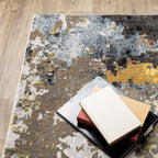 Modern abstract area rug with distressed gold, gray, and blue speckled pattern