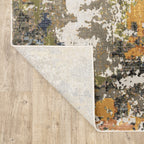 Modern abstract area rug with distressed gold, gray, and blue speckled pattern