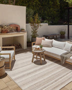 Neutral striped outdoor rug in beige and grey tones on patio