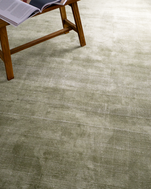 Sage green textured velvet rug with subtle worn vintage distressing throughout