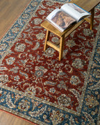 Red traditional rug with ornate floral patterns and blue border design