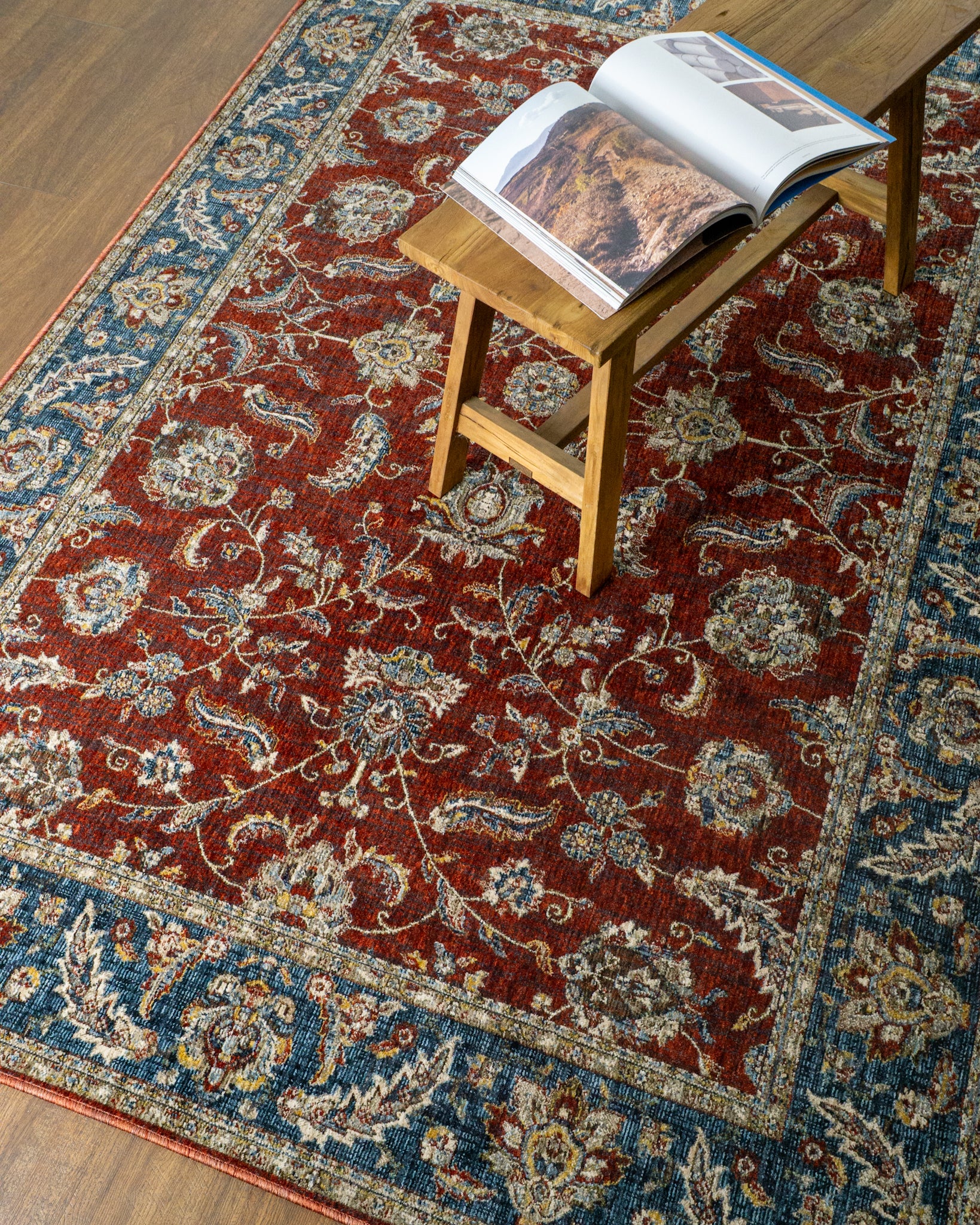 Red traditional rug with ornate floral patterns and blue border design