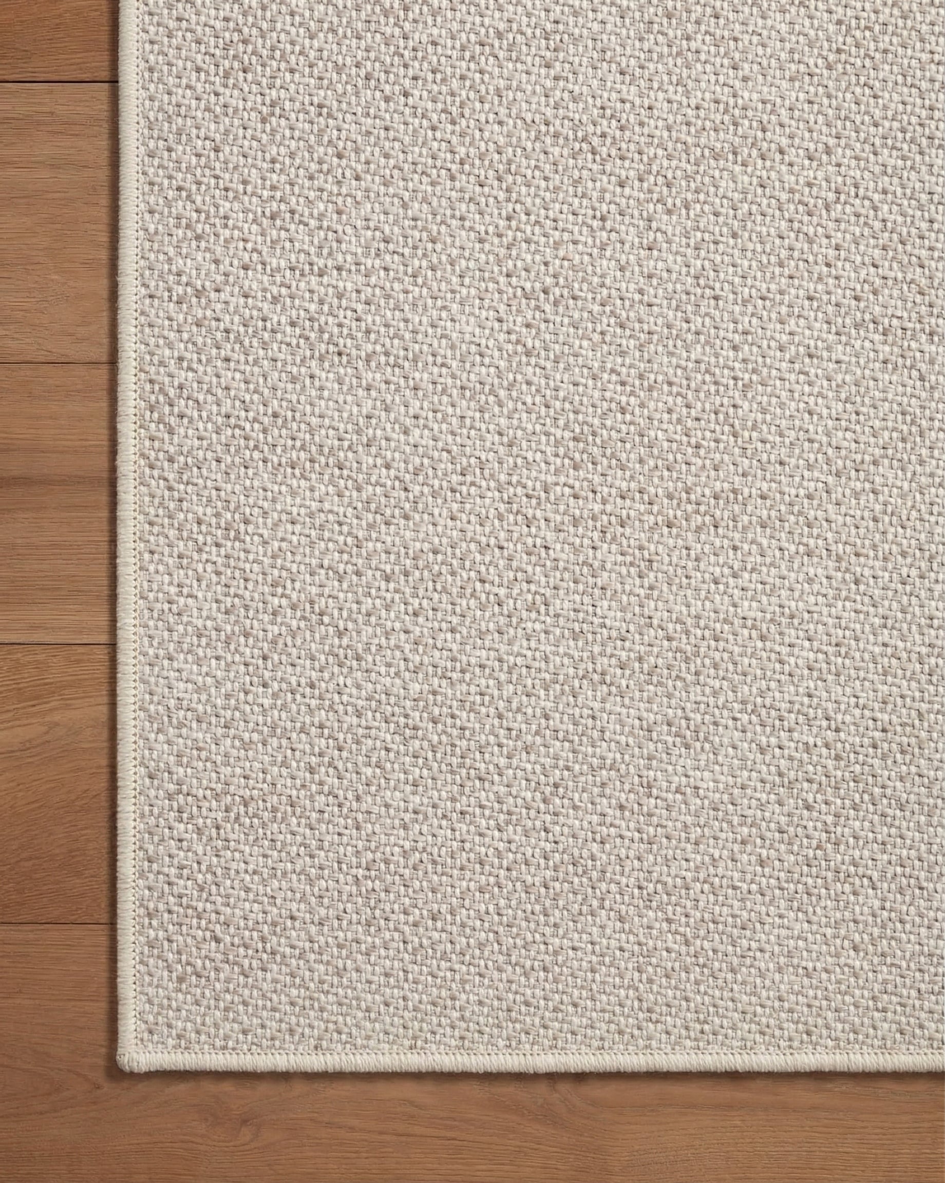 Neutral beige herringbone textured rug with subtle woven pattern throughout