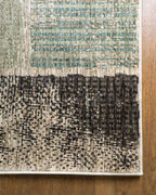 Modern geometric patchwork rug in green, black, and neutral tones with textured weave